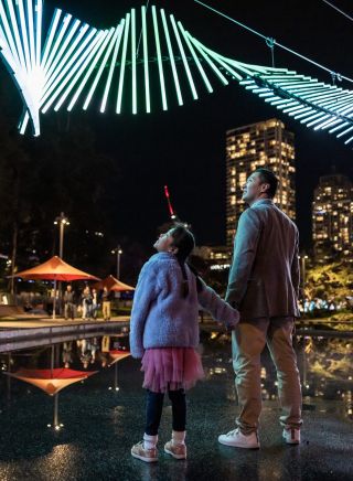 Father & daughter enjoying the "Swarm" light installation at Vivid Sydney