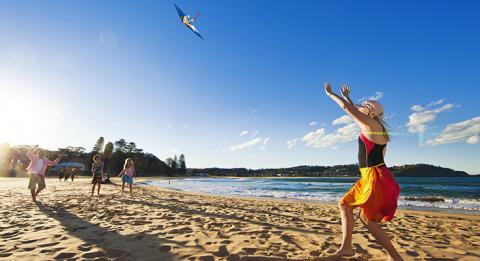 Family flying a kite on Avoca Beach, Central Coast Avoca Beach, Central Coast