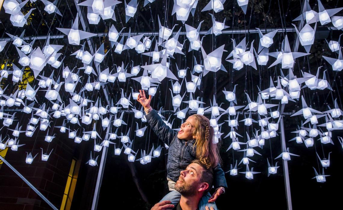 First Fleet Park, The Rocks during Vivid Sydney 2018 Family enjoying a close-up view of the 1000 Cranes light installation at First Fleet Park, The Rocks during Vivid Sydney 2018
